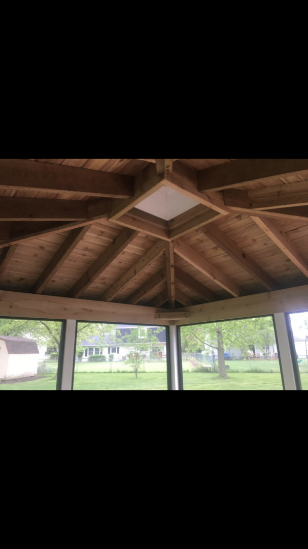 A large room with a ceiling fan and windows.