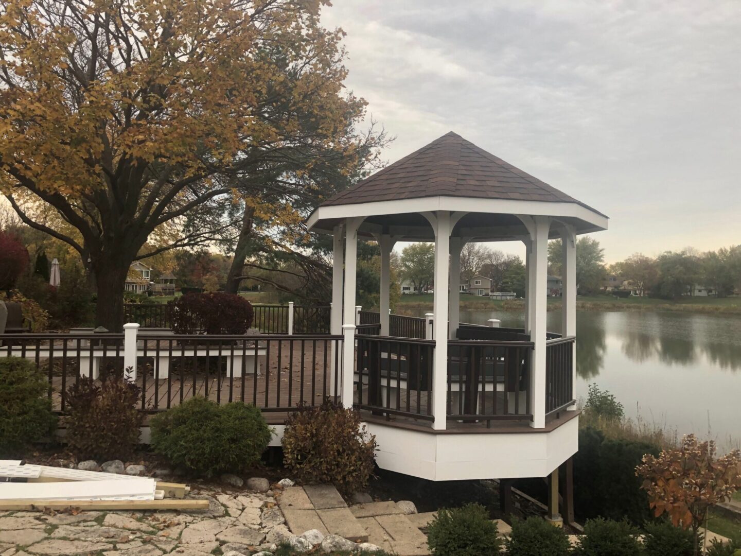 A gazebo sits on the edge of a lake.