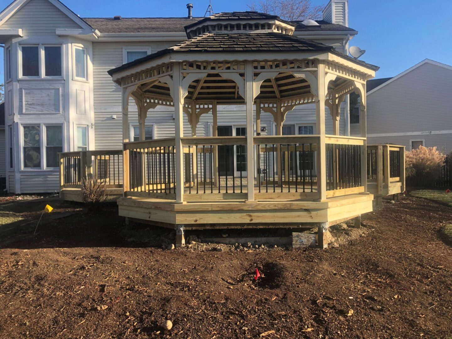 A gazebo in the middle of a yard.