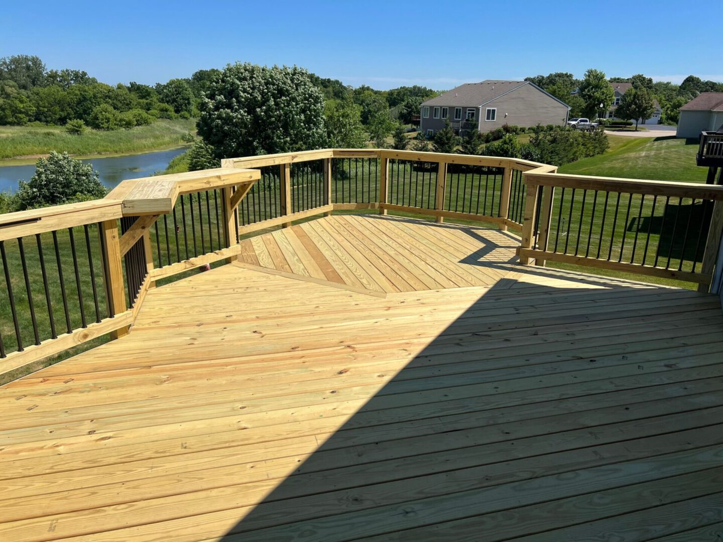 A wooden deck with a lake in the background.