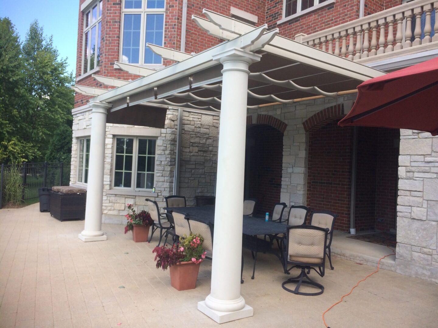 A patio with tables and chairs under an awning.