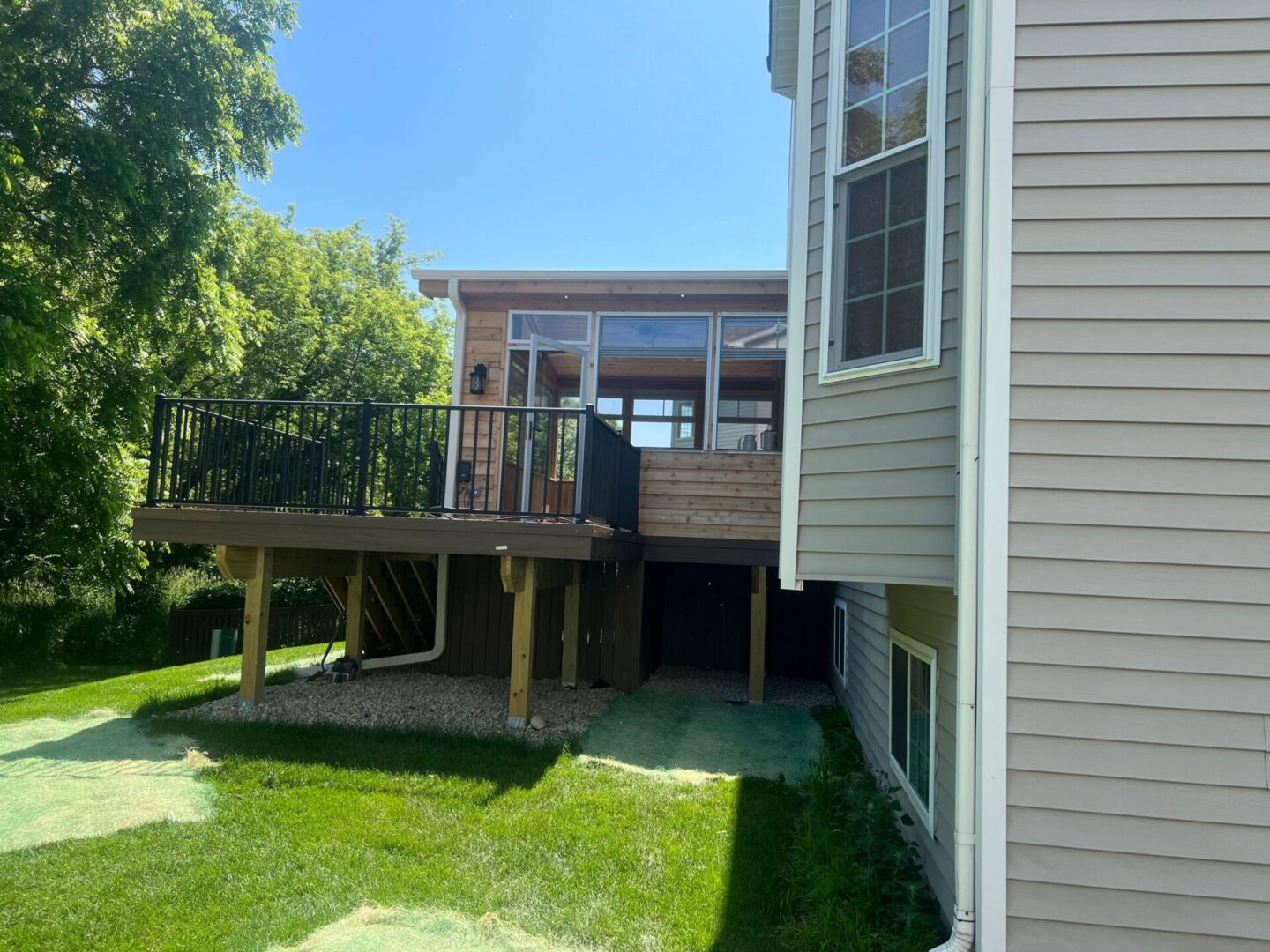 A house with a deck and grass in the yard